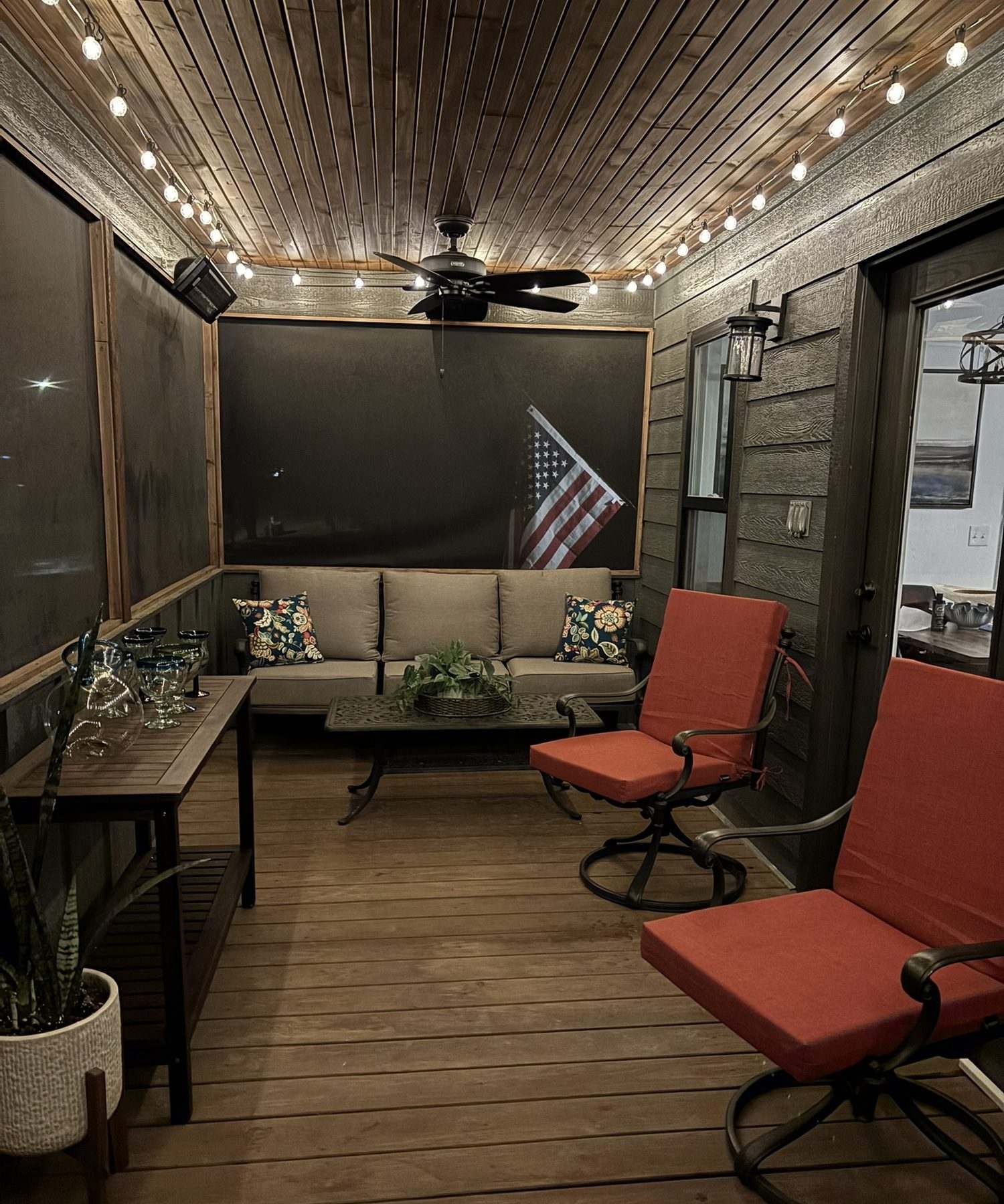 The screened porch at night under warm string lights